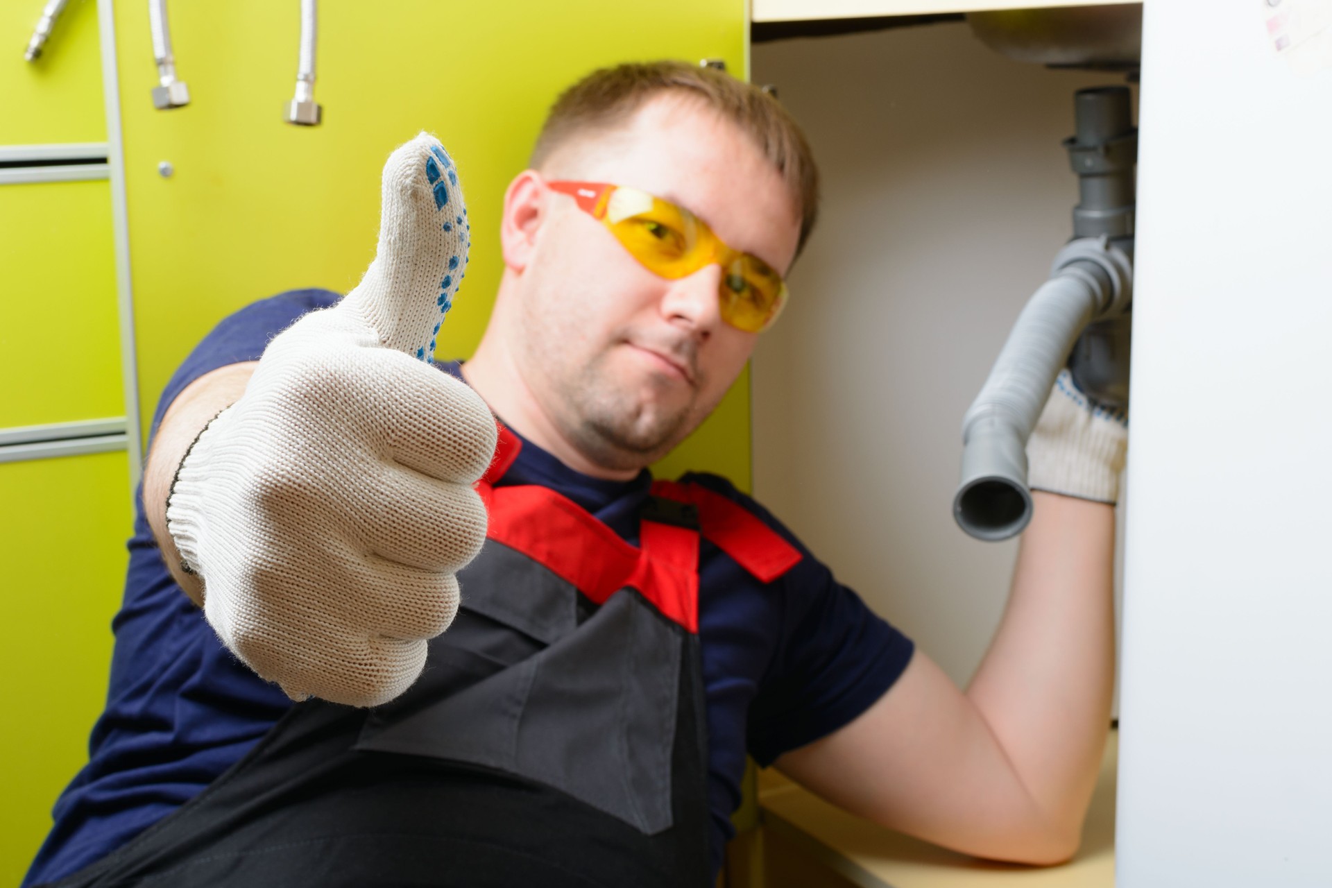 Klempner in der Küche reparieren das Wasserrohr